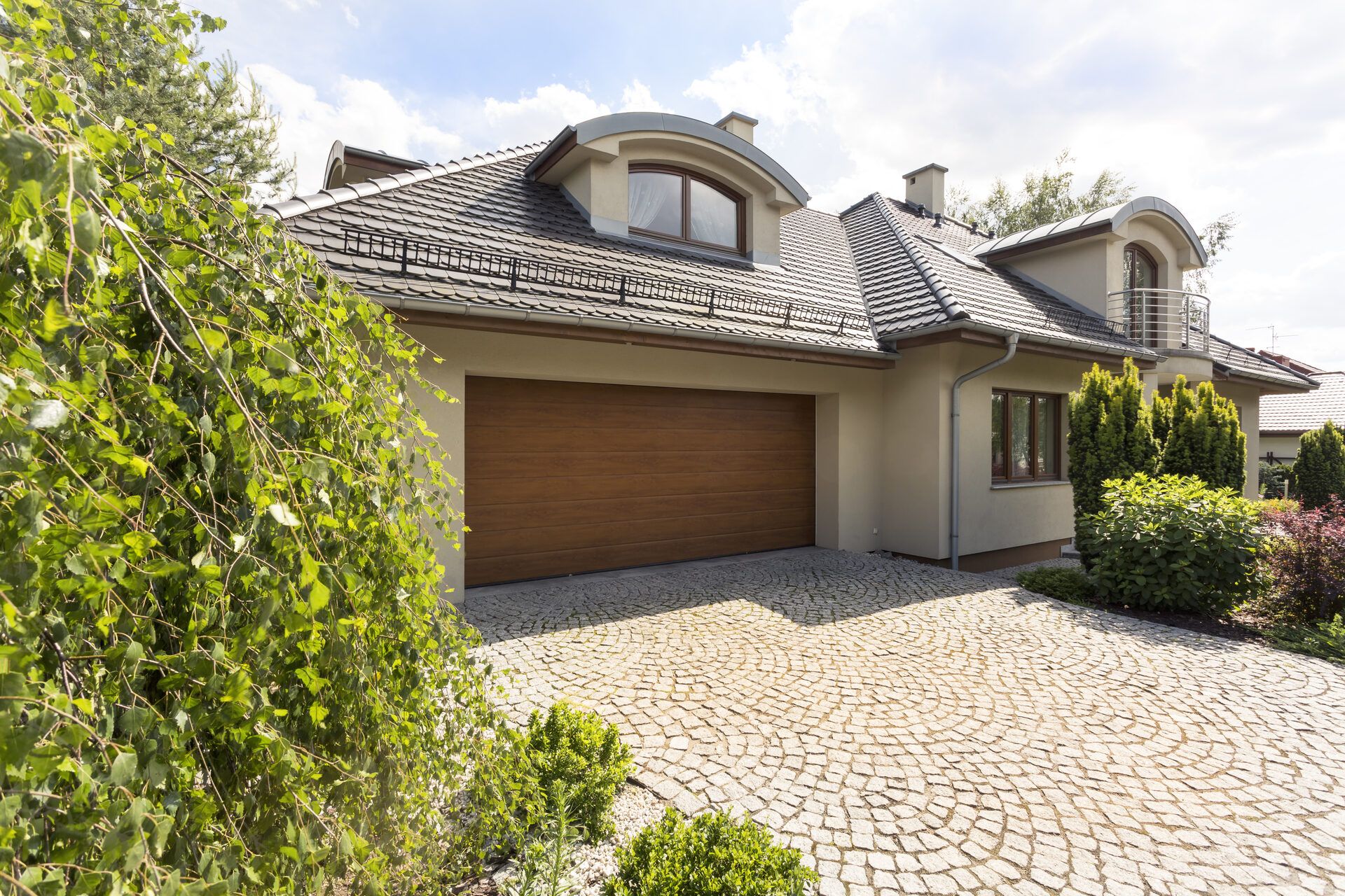 Suburban home exterior with paved driveway and landscaping