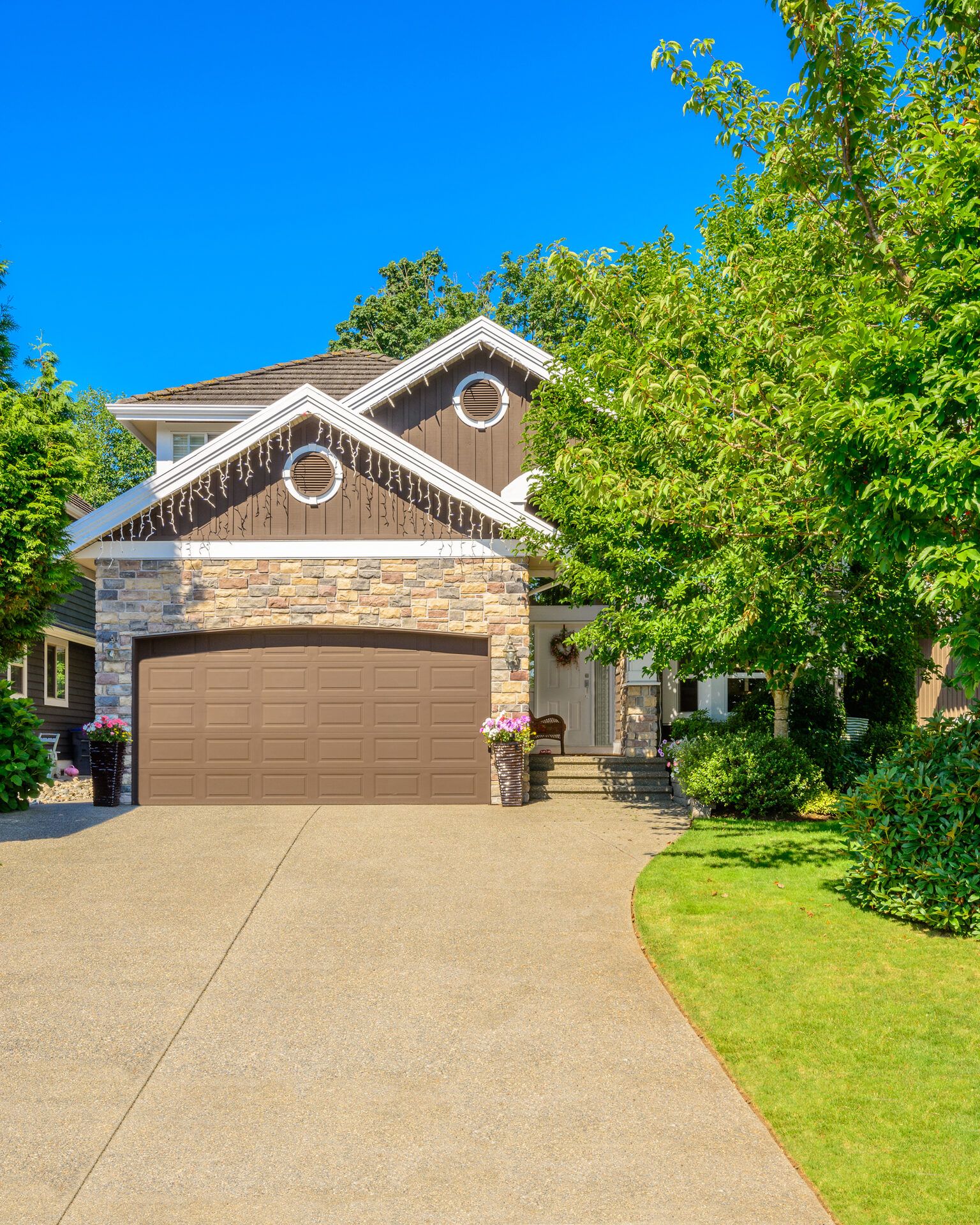 Luxury home with double garage doors against a clear blue sky