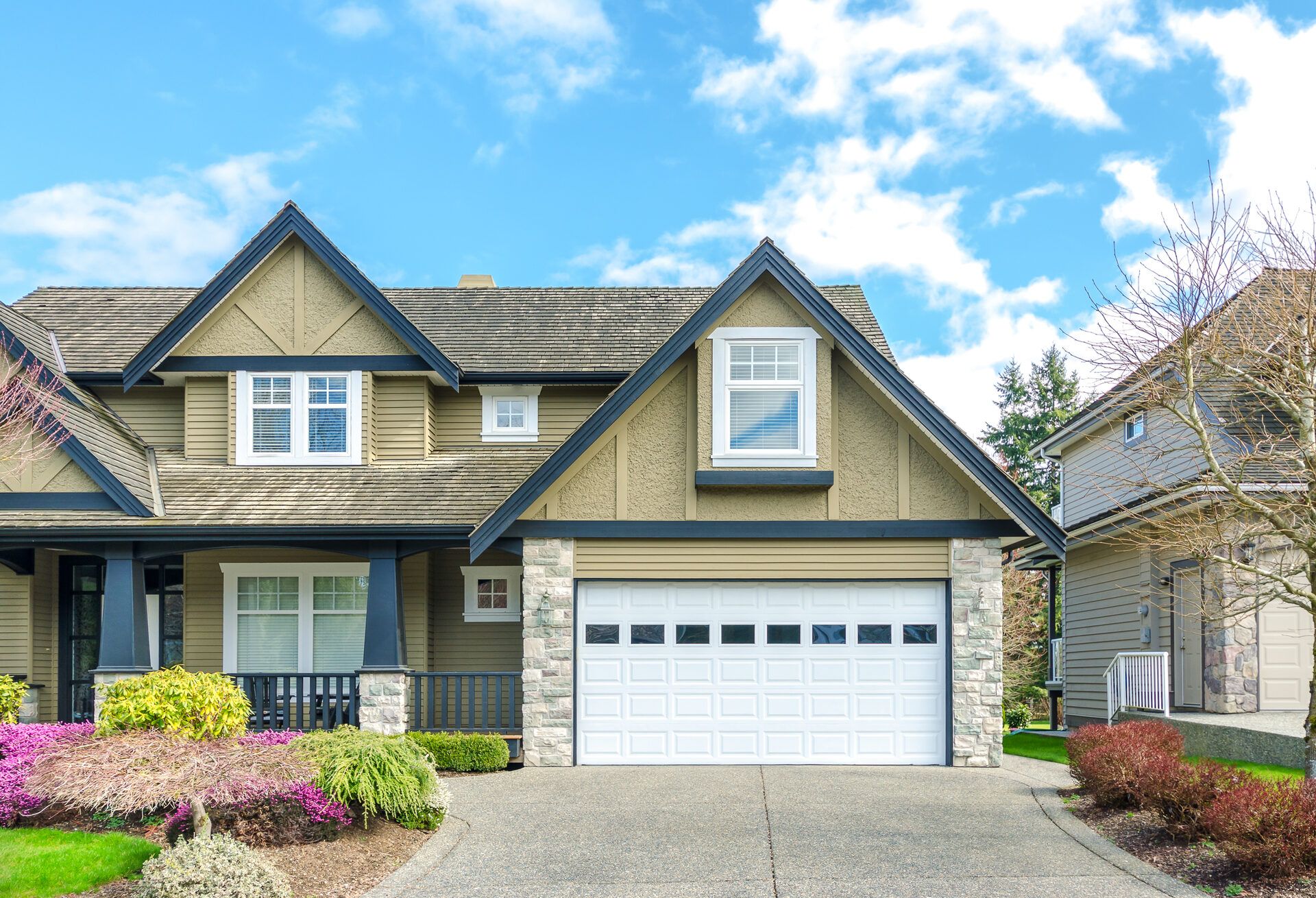 Two-car garage entrance of a luxury home with paved driveway