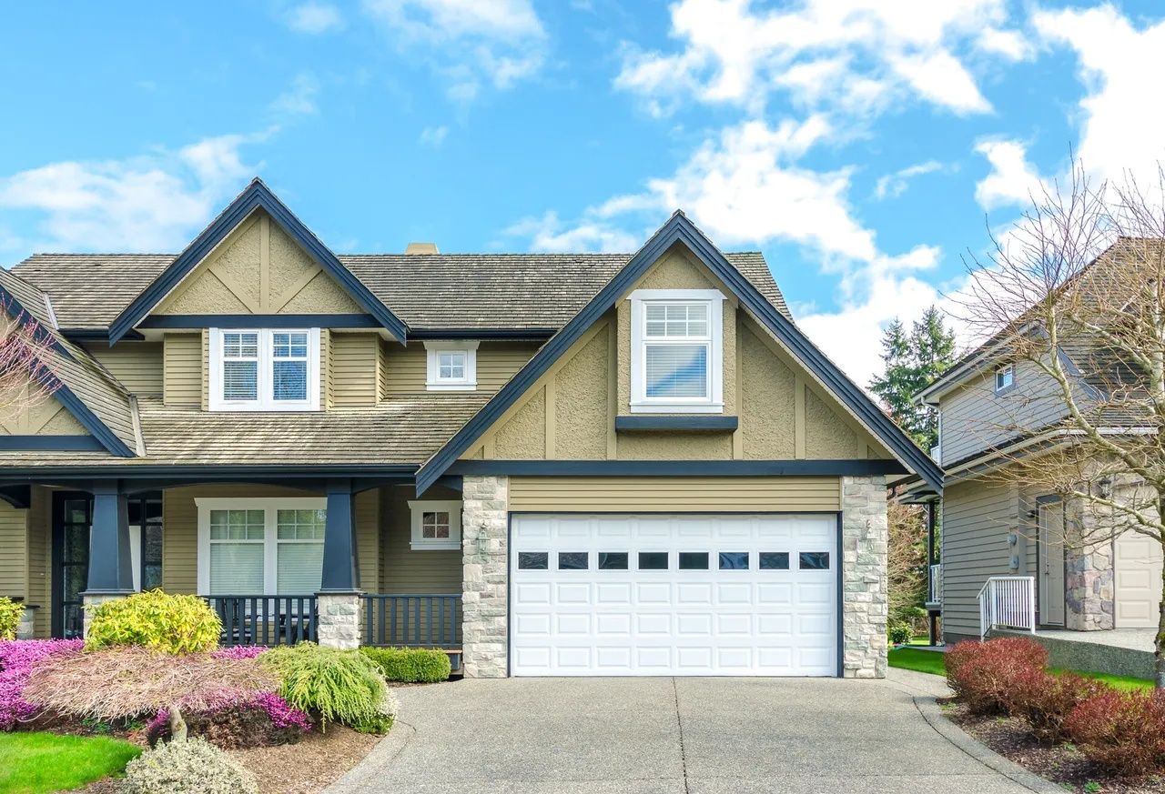 Two-car garage entrance of a luxury home with paved driveway