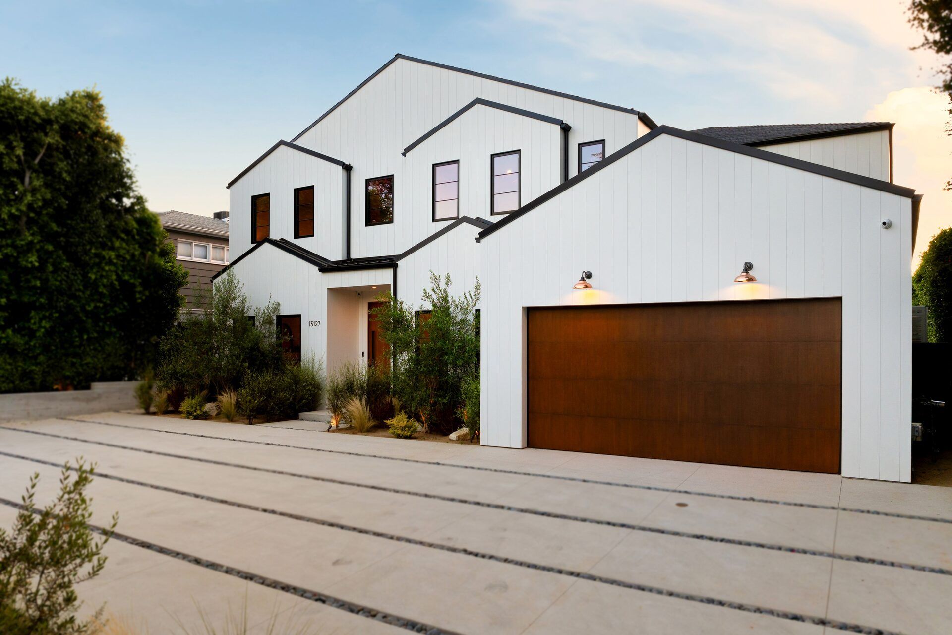 Modern white home featuring a natural wood double garage door